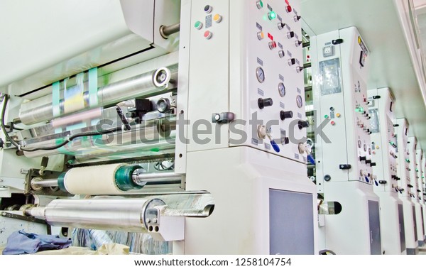 doypack making packaging machine in\
modern factory with white rolls  and plastic film\
running