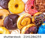 Dozen assorted donuts with Chocolate, Boston Creme, Cinnamon Bun, glazed and maple, close up photograph.