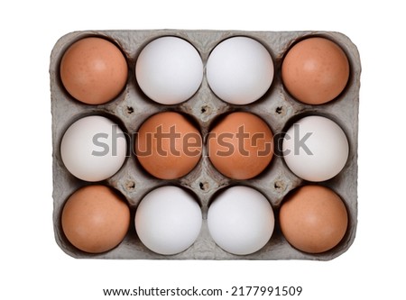 A dozen eggs, 6 white and 6 brown, in a large carton isolated on white