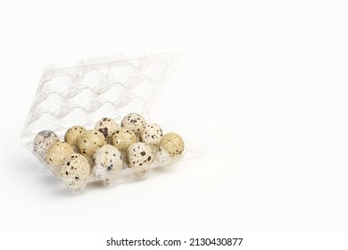 A dozen of quail eggs in a plastic tray on a white background with copy space
