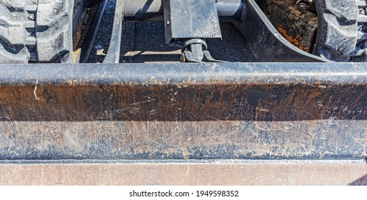 The Dozer Blade Of An Excavator, Shows Signs Of Heavy Duty Use Over The Years, With All Its Scratches, Dents And Rust.