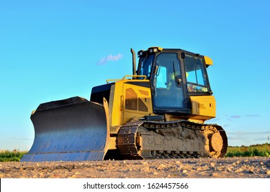 Dozer with buckets at construction site. Bulldozer during land clearing, grading, pool excavation, utility trenching and foundation digging. Possible granularity