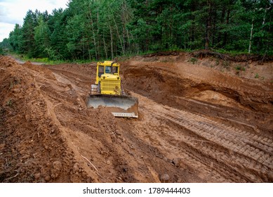 Dozer during clearing forest for construction new road . Yellow Bulldozer at forestry work Earth-moving equipment at road work, land clearing, grading, pool excavation, utility trenching