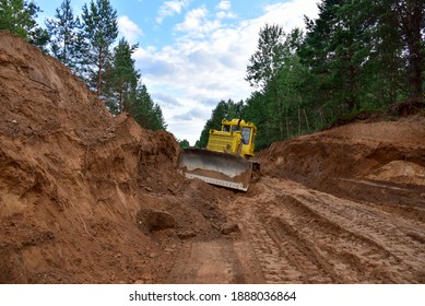 Dozer during clearing forest for construction new road . Yellow Bulldozer at forestry work Earth-moving equipment at road work, land clearing, grading, pool excavation, utility trenching