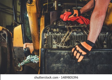 Dozer Repair by Professional Caucasian Mechanic. Closeup Photo. Construction Machines Industry Theme.