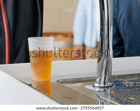 Draft beer served in a reusable cup at a corporate reception, networking event or catering service, highlighting hospitality and refreshment concepts.
