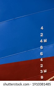 Draft Mark Numbers On Side Of Blue And Red Rust Proof Steel Hull Of Fishing Vessel In Vertical Frame