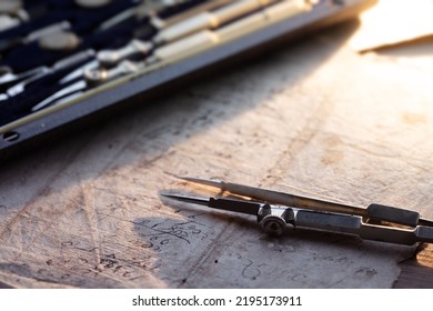 Drafting, retro style. Vintage compass or divider with drafting set in background. Shallow depth of field.