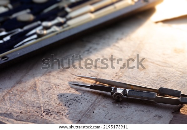 Drafting, retro
style. Vintage compass or divider with drafting set in background.
Shallow depth of
field.