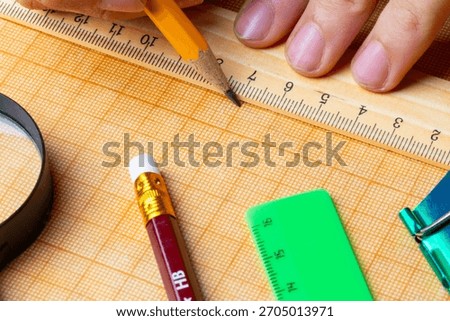 draftsman draws on a ruler on the graph paper