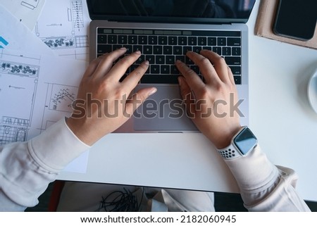 Draftsperson working on portable computer in workplace