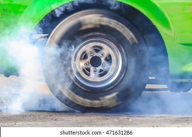 Drag car burning tire for warm up tire before competition, Drag wheel spinning wheel and smoking.