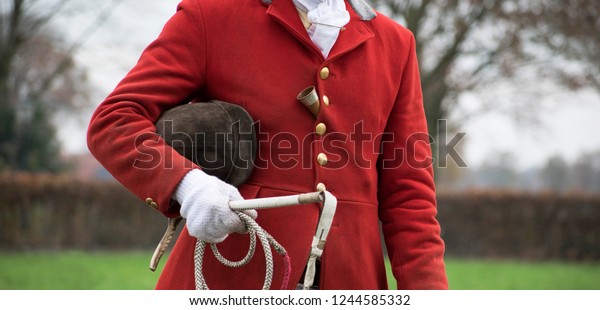 drag hunt portrait drive master. Red coat fox hunt. With\
cap, whip and horn. hunting scene. Tradition. Netherlands rural\
area. 