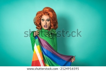 Drag queen celebrating gay pride holding rainbow flag - LGBTQ social community concept