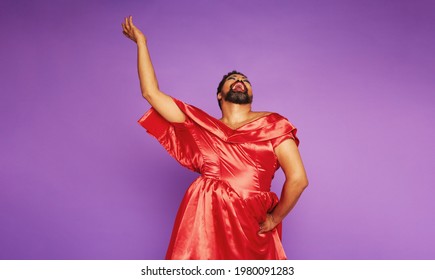 Drag queen singing on purple background. Gender queer male performing in studio.