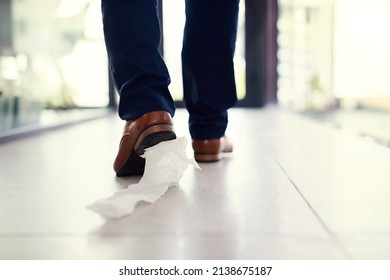 Dragging His Embarrassment Along. Closeup Shot Of A Businessman Walking In An Office With Toilet Paper Stuck To His Shoe.