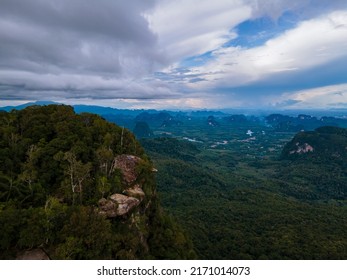 Dragon Crest mountain Krabi Thailand, a Young traveler sits on a rock that overhangs the abyss, with a beautiful landscape. Dragon Crest or Khuan Sai at Khao Ngon Nak Nature Trail in Krabi, Thailand - Shutterstock ID 2171014073
