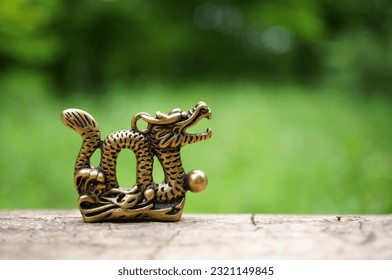 Dragon figurine on a green background. Astrology and horoscopes.