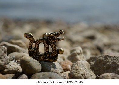 Dragon Figurine On The River Bank. Talismans And Amulets. A Symbol Of Supernatural Power.