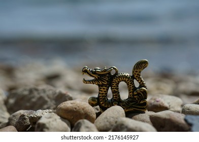 Dragon Figurine On The River Bank. Talismans And Amulets. A Symbol Of Supernatural Power.