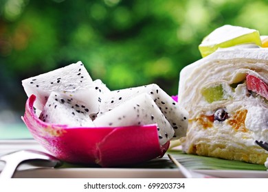 Dragon Fruit And Fruit Cake In A Dish, Bokeh Background With Green Color Of The Tree, Near The Pool, Summer Concept, Fresh And Relax.