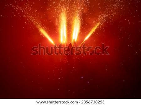 Dragon head looking upward expelling fireworks from its wings and creating a shower of fire sparks that fall and dimly illuminate the darkness of the underworld or hell in red
