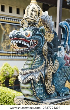 Dragon like statue in Pura Tanah Lot temple in Bali, Indonesia. Colorful wooden carved dragon statue. Dragon (naga) guardian statue at Balinese Hindu temple. Iconic religious landmark of Bali. 