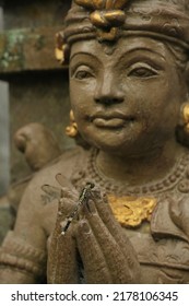 Dragonfly on Balinese Hindu statue hands. Dragonfly on hands of statue close up. Balinese Hinduism. Bali, Indonesia.