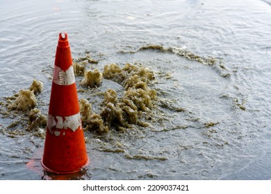 Drain After Severe Spring Storm On Flooded Street. Sewage Overflow On Pavement During Rain