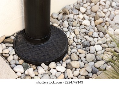 Drain Pipe into Ground Floor with Drain Stones Outside Building. French drain. Modern Drainage Stormwater of House. Drainage Exterior Facade.