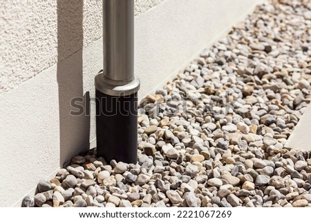 Drain pipe or Sewer install in French drain under Stones Floor or Drain Gravel Cover, Modern Water Drainage System near House Foundation. To collect Stormwater from downspout outlet, storm gutter.