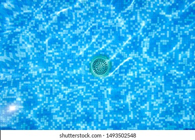 Drain Of A Pool, Seen Through The Water From Above.