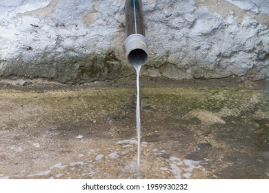 A Drain With Water Running Down From The Roof During Rain.