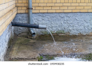 A Drain With Water Running Down From The Roof During Rain.