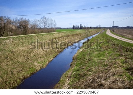 Drainage ditch along the road. View of the roadside, along which a deep ditch was dug to drain rainwater. Road reconstruction. Latvia