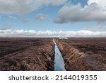 Drainage ditch in the peat extraction site. Drainage and destruction of peat bogs.