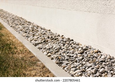 Drainage Gravel, French Drain, Drain Stones, Pebble Around Perimeter Of House. Drain Floor For Rain Storm Water Near Building Wall.