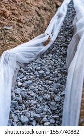 Drainage Rock In A French Drain As Part Of A DIY Home Repair Of Drainage Issues