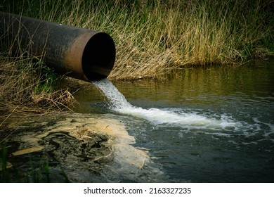 Draining sewage from pipe into river, pollution rivers and ecology - Shutterstock ID 2163327235