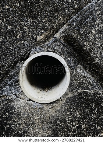The drainpipe between the large walls.