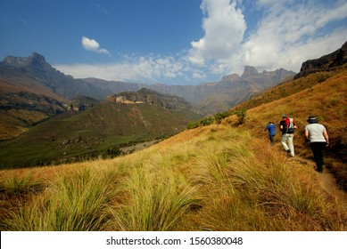 Drakensberg Mountains, South Africa, August 2012, A Family Walking On A Footpath Towards The Impressive Mountain Formation „amphitheater“.