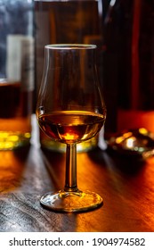 Dram of single malt scotch whisky and bottles on background, close up