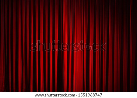 Drama theatre concept. Dark red colour stage curtain before show. Deep shadows. Text-space. Indoor shot