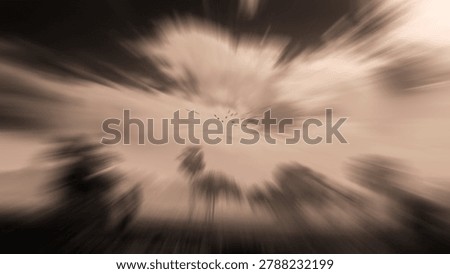 Dramatic abstract nature background with radial zoom blur effect on flying birds and village trees in sepia tone