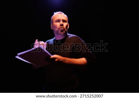 Dramatic actor with scenario rehearsing on theater scene with lighting	