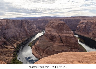 A dramatic aerial view of Horseshoe Bend, a stunning rock formation carved by the Colorado River. This natural wonder showcases the unique horseshoe-shaped bend in the canyon. - Powered by Shutterstock