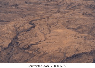 dramatic aerial view of the texture and patterns on the barren desert landscape from an airplane in the middle east.