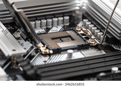 Dramatic angle captures a modern computer motherboard, highlighting the central processing unit (CPU) socket surrounded by capacitors, RAM slots, and other sophisticated components.