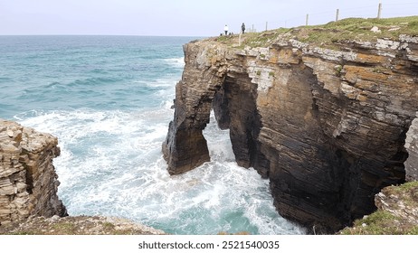 Dramatic archway, Ocean waves, Rugged cliffs, Coastal beauty, Scenic vista, Turquoise waters, Natural formation, Serene landscape, Rocky shoreline, Sunlit seascape, Tide pools, Majestic view - Powered by Shutterstock