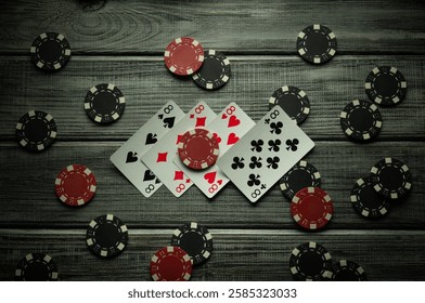 The dramatic arrangement of playing cards with a combination of four of a kind or quads next to scattered poker chips creates a tense atmosphere of gambling. Perfect for poker enthusiasts.